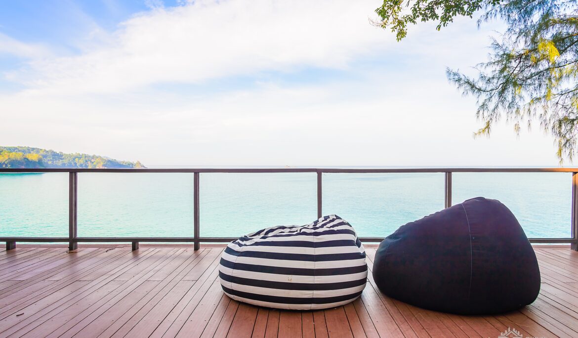 Dubai sea view wooden deck with glass balustrade and striped bean bags — DubaiRenovate